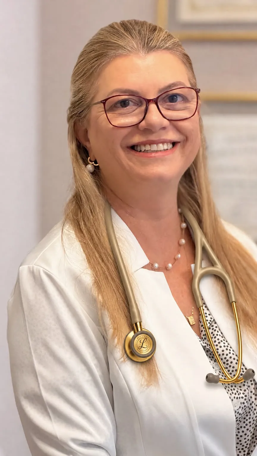 Dra. Fernanda Vizzotto Toreto, de jaleco e estetoscópio, no consultório